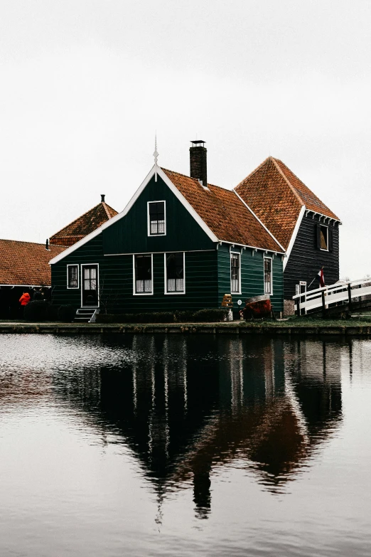 a couple of houses sitting on top of a body of water, by Jan Tengnagel, pexels contest winner, renaissance, barn, trending on vsco, dutch style, low quality photo