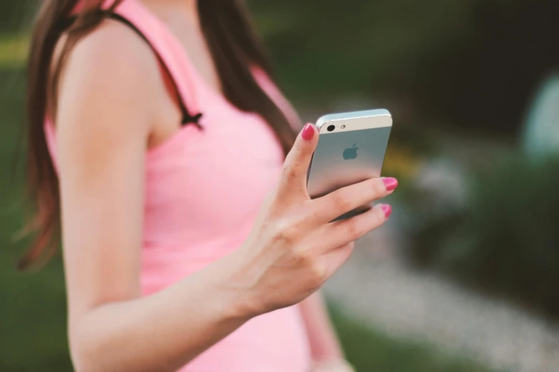 a close up of a person holding a cell phone, pexels, pink body, fit girl, from the distance, with apple