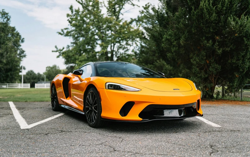 an orange sports car parked in a parking lot, inspired by Bernardo Cavallino, unsplash, mannerism, long front end, open synthetic maw, 🦩🪐🐞👩🏻🦳, f 3 2