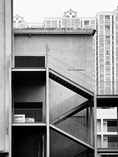 a black and white photo of a building with stairs, inspired by Thomas Struth, cinematic. by leng jun, phong yintion j - jiang geping, kowloon, fernando guerra