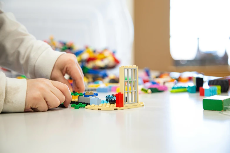 a child playing with legos on a table, pexels contest winner, medical research facility, white wall coloured workshop, profile image, thumbnail