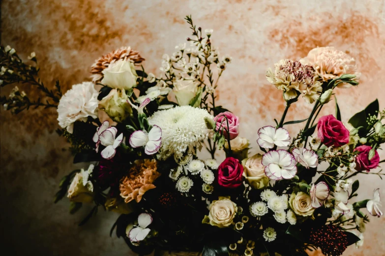 a vase filled with lots of flowers on top of a table, by Elsie Few, trending on unsplash, baroque, earthy colours, sydney hanson, stunning arcanum backdrop, rose-brambles