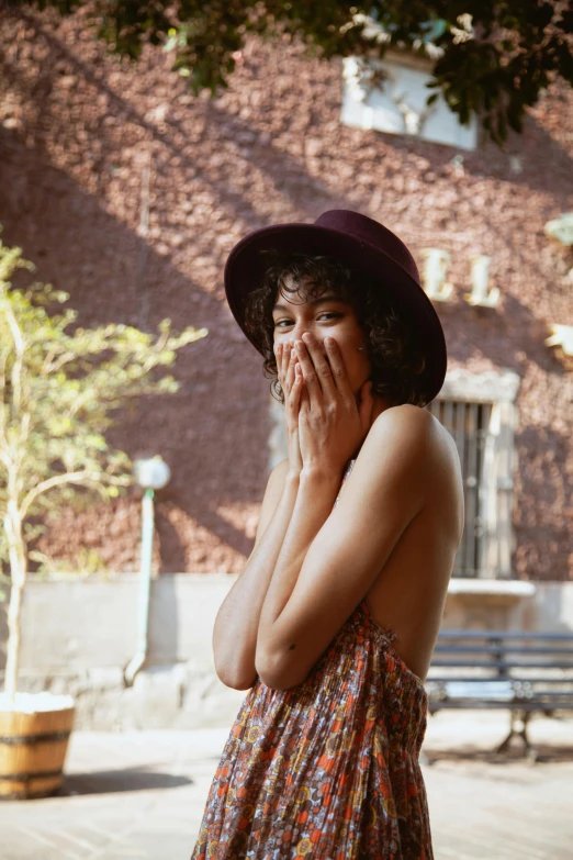 a woman with a hat covering her face, pexels contest winner, jamel shabazz, wearing a sun dress, childish gambino, fall season