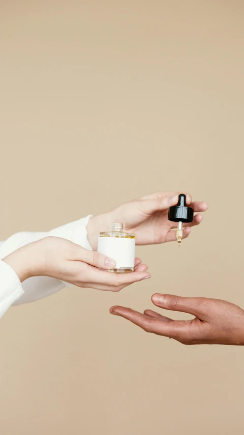 a woman putting a ring on a man's finger, an album cover, by Arabella Rankin, unsplash, minimalism, painting of one health potion, skin care, caramel, miniature product photo