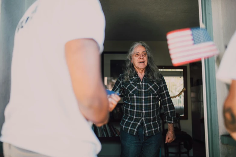 a man standing next to a woman holding an american flag, a photo, pexels contest winner, renaissance, playing games, grandma, blurry footage, avatar image