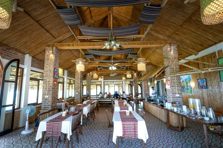 a dining room filled with lots of tables and chairs, wooden ceiling, ivan bolivian, lake view, profile image