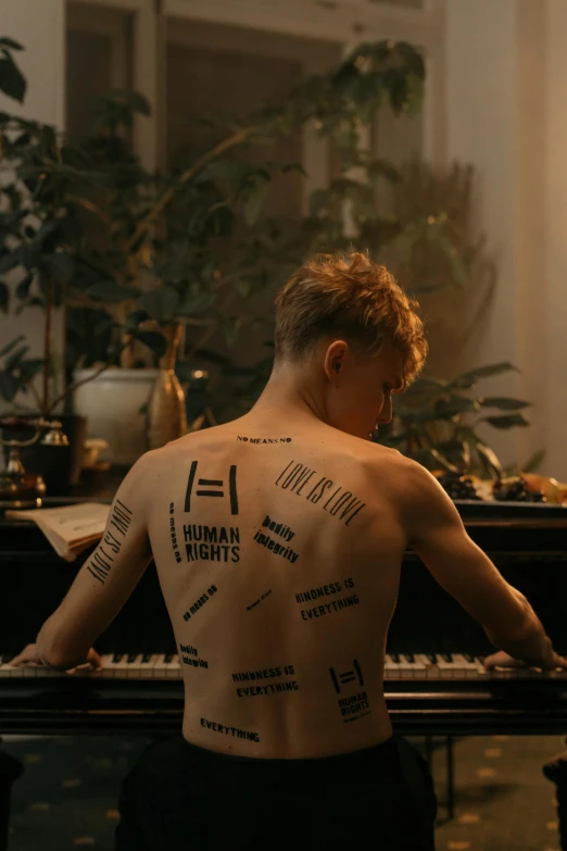 a man with tattoos on his back playing a piano, an album cover, by Anna Füssli, trending on pexels, dada, blond boy, sophia lillis, made of flesh and muscles, covered in runes