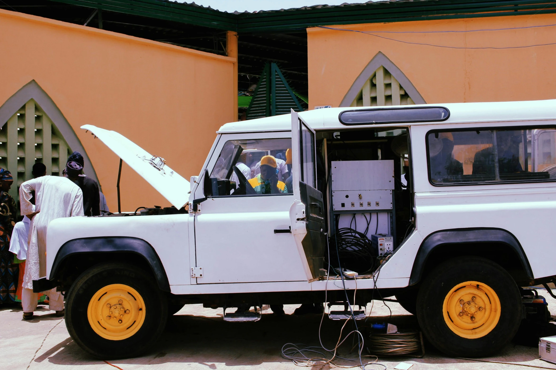 a white land rover parked in front of a building, an album cover, by Sven Erixson, pexels contest winner, with electric arc device, inside of a car, diagnostics, system unit