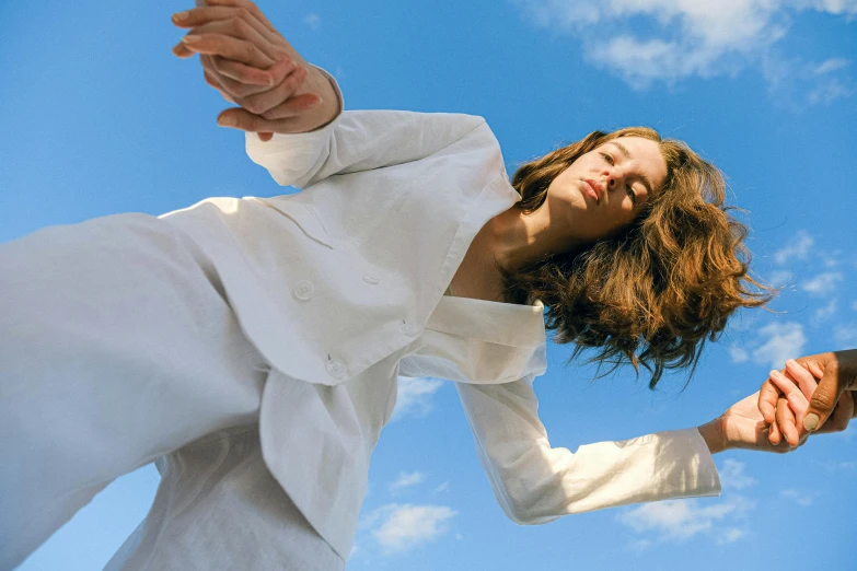 a woman flying through the air while holding a tennis racquet, an album cover, unsplash, magic realism, wearing white suit, issey miyake, blue skies, model wears a puffer jacket