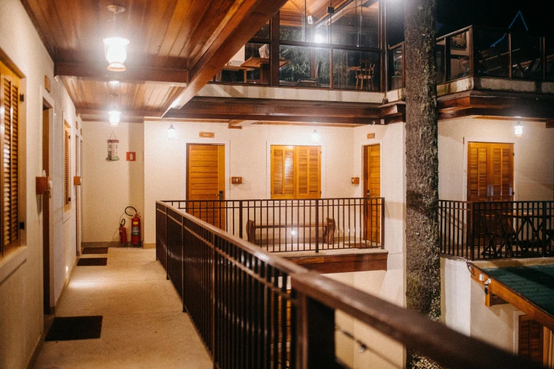 the inside of a building with a balcony and balusted balusted balusted balusted balusted balusted bal, unsplash, beachwood treehouse, it's night time, adjacent hallways, brightly lit - style atmosphere