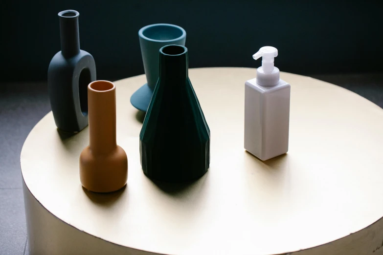 a group of vases sitting on top of a table, a still life, inspired by Giorgio Morandi, unsplash, plasticien, soap, futuristic product design, holding a bottle, detailed product image