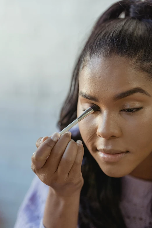 a woman is doing makeup on her face, by Carey Morris, complimentary eyeliner, natural complexion, covered, soft texture