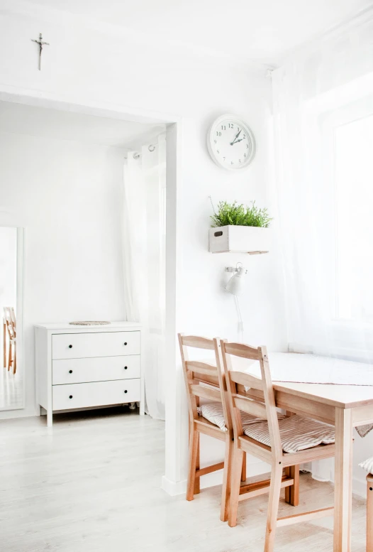 a dining room table with chairs and a clock on the wall, inspired by Constantin Hansen, unsplash, minimalism, white room, small bedroom, profile image, houzz