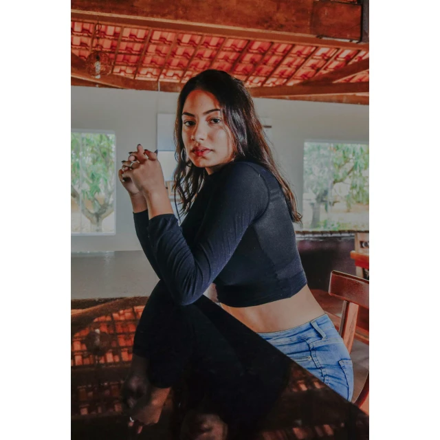 a woman sitting on top of a wooden table, wearing crop top, instagram photo, profile image, nivanh chanthara