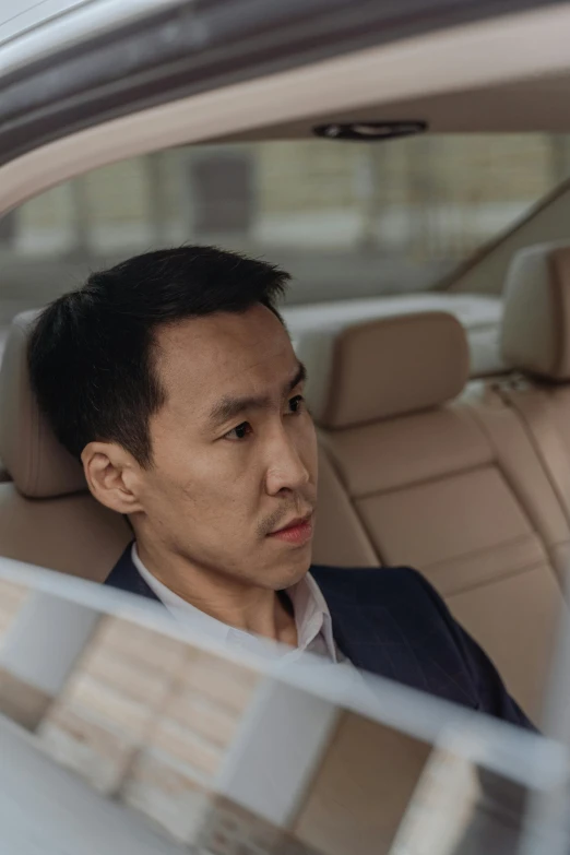 a man sitting in the passenger seat of a car, inspired by Li Tiefu, looking confused, darren quach, **cinematic, ceo