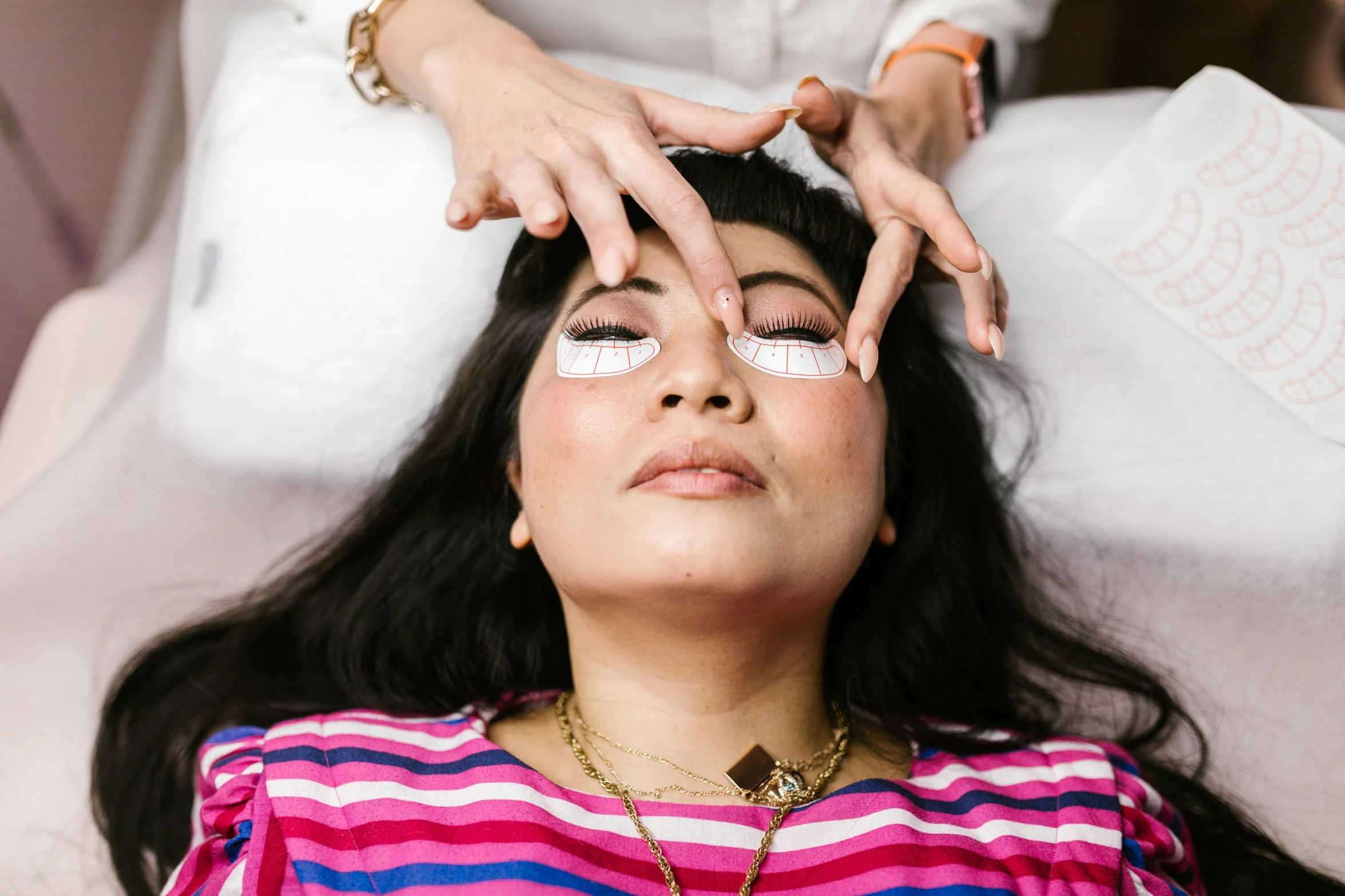 a woman getting her eyebrows done at a beauty salon, by Julia Pishtar, opening third eye, manuka, lying down, blind eyes
