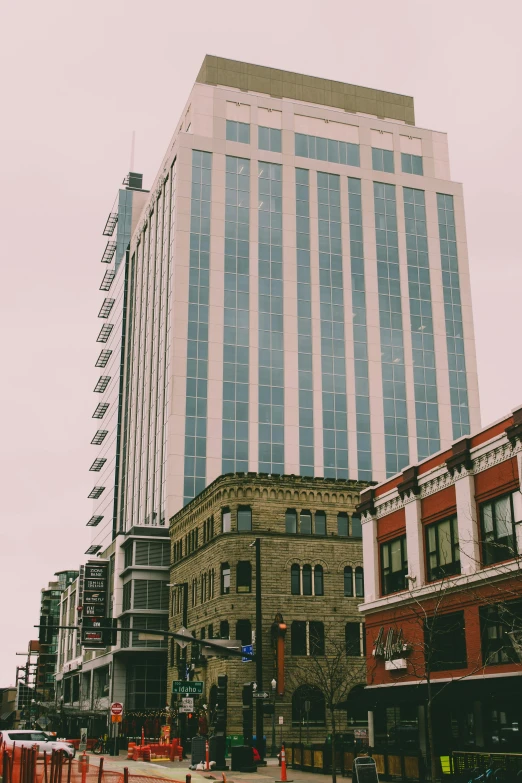 a very tall building sitting in the middle of a city, by Jessie Algie, unsplash, vancouver school, gray skies, wellington, low quality photo, sunfaded