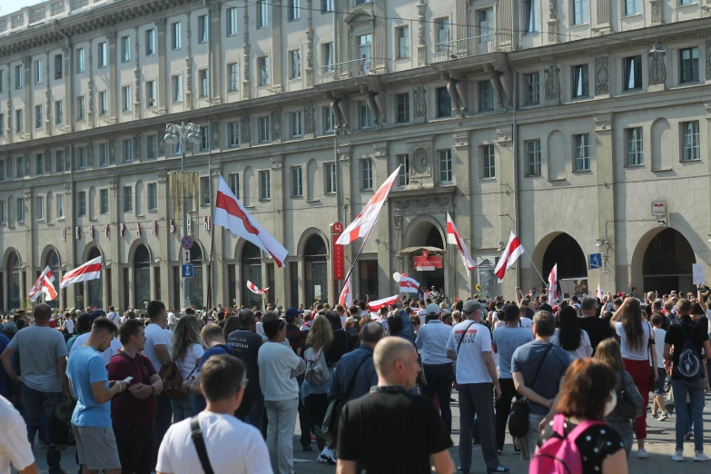 a large group of people standing in front of a building, flags, florence, manifestation, profile image