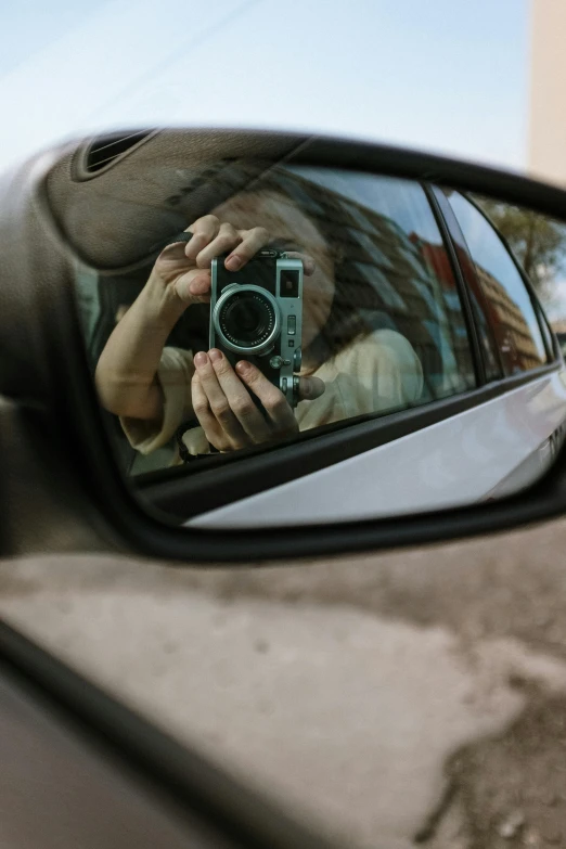 a woman taking a picture of herself in a rear view mirror, a picture, inspired by Vivian Maier, unsplash contest winner, hasselblad photo, 2019 trending photo, cracked mirror, sports photo