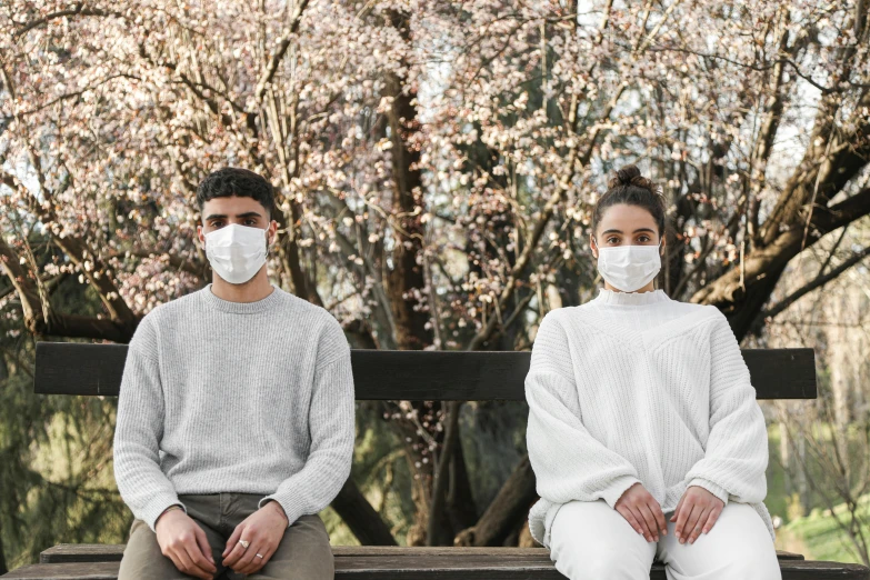 two people wearing face masks sitting on a bench, a portrait, trending on pexels, sakura season, wearing white clothes, avatar image, scientific