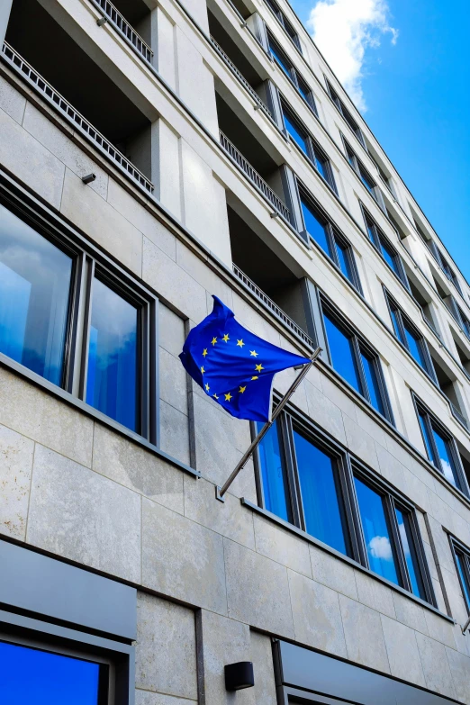 a european union flag flying in front of a building, unsplash, square, slide show, thumbnail, smooth in _ the background