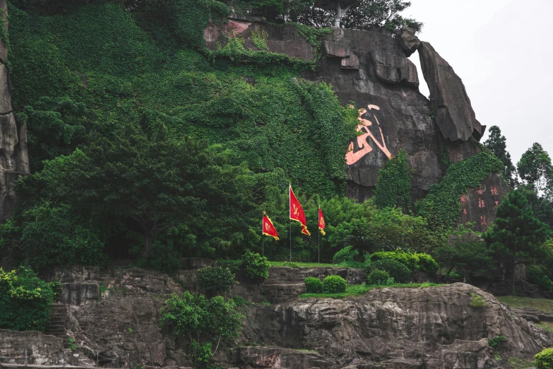 a man flying through the air over a lush green hillside, a statue, inspired by Ren Hang, pexels contest winner, gutai group, soviet flags, the village on the cliff, hangzhou, grey