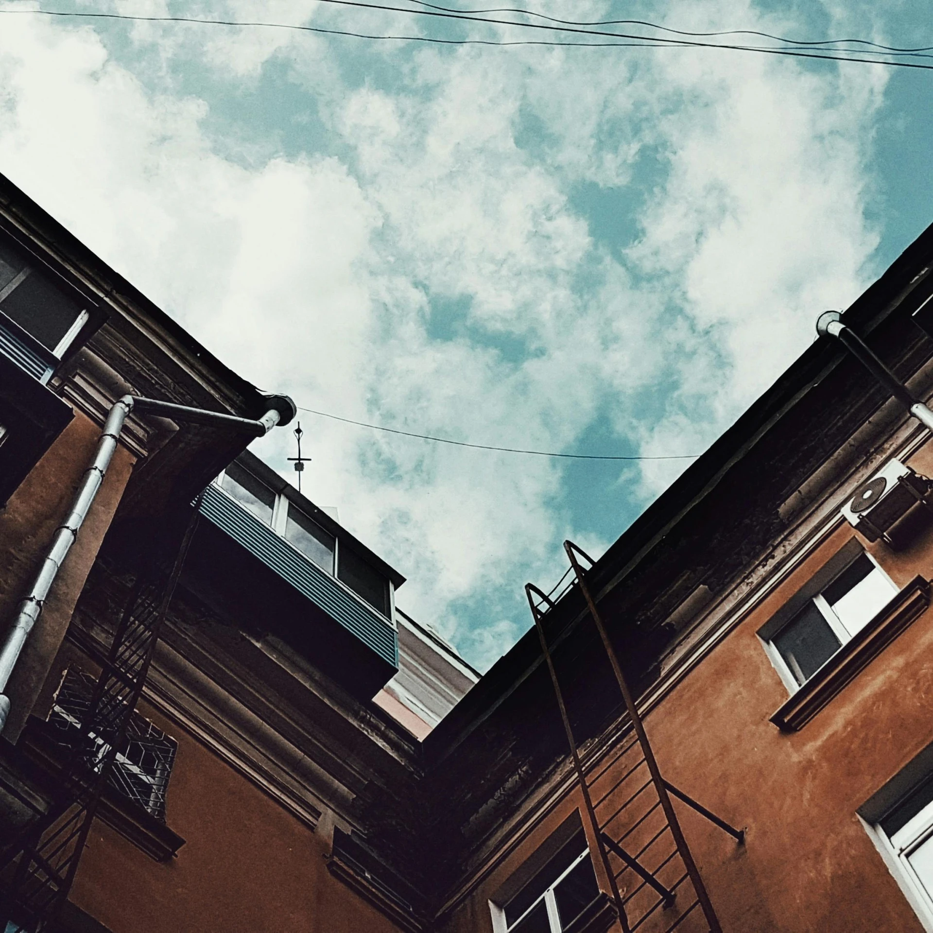 a couple of buildings that are next to each other, a photo, inspired by Elsa Bleda, unsplash, summer sky, alleys, anna nikonova, partly cloudy sky