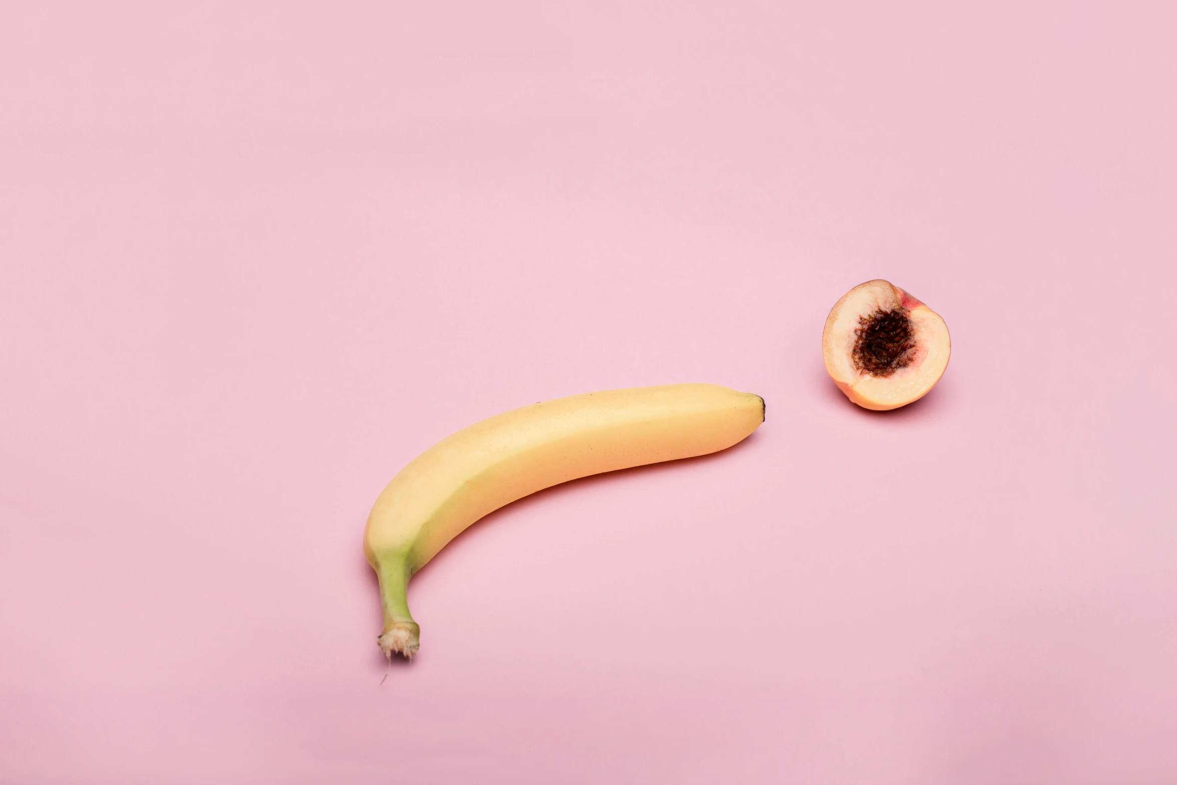 a banana and a peach on a pink background, by Niko Henrichon, trending on pexels, sexually attractive, oesophagus, on grey background, contracept