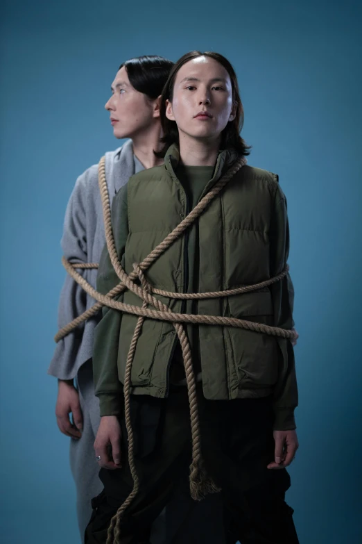 a couple of people standing next to each other, an album cover, inspired by Sarah Lucas, unsplash, conceptual art, rope bondage, combat vest, boys, genderless