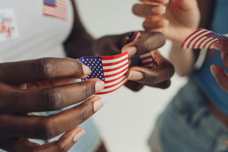 a group of people holding small american flags, by Emma Andijewska, pexels contest winner, single pair of hands, looking from side, 🦩🪐🐞👩🏻🦳, african american