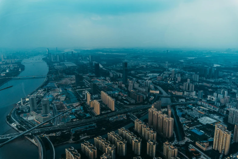 an aerial view of a city with lots of tall buildings, by Daniel Lieske, pexels contest winner, happening, zezhou chen, panoramic, view from helicopter, ominous and intense