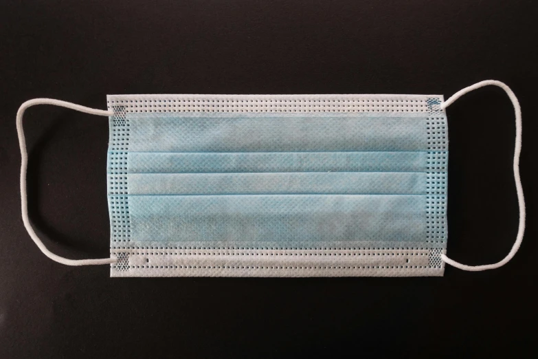 a surgical mask on a black background, rectangular, light blue, thumbnail, contain