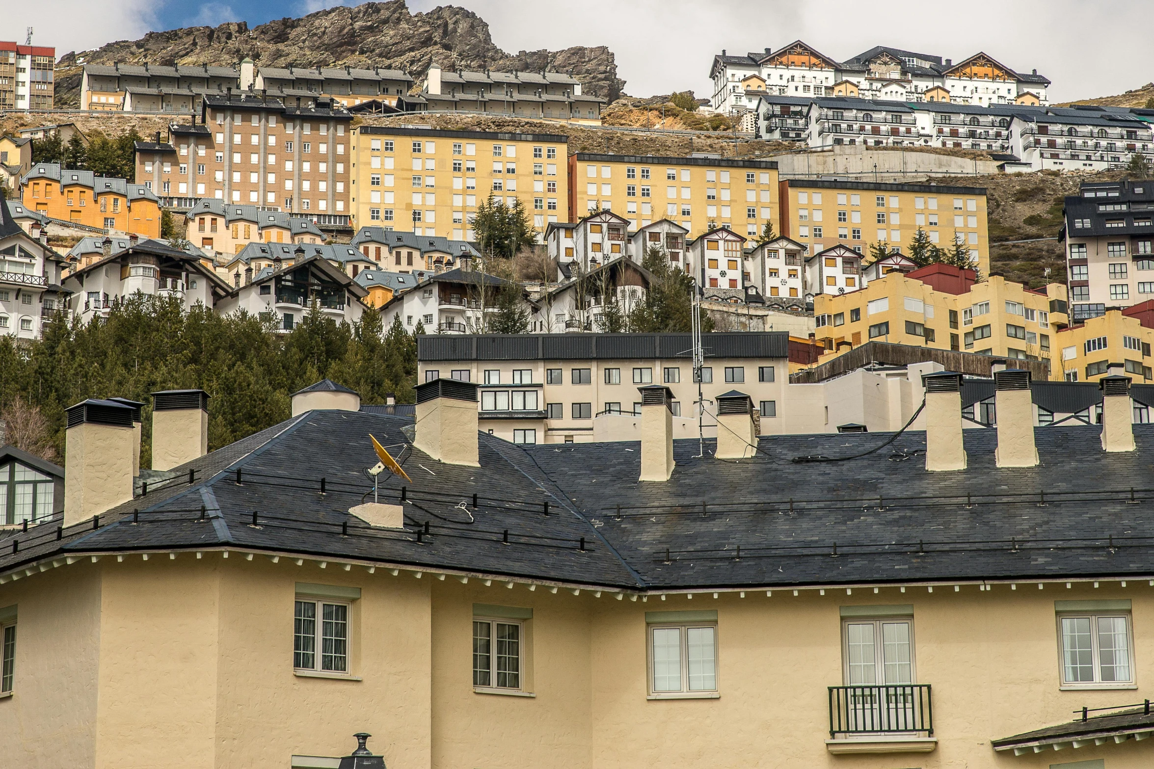 a group of buildings sitting on top of a hill, by Carlo Martini, unsplash, art nouveau, alpine climate, spanish, grey, svend smital