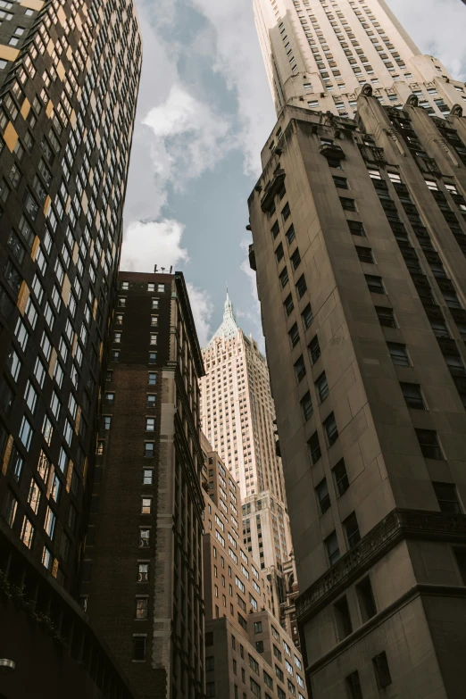 a group of tall buildings sitting next to each other, in the middle of new york, art deco architecture, low quality photo, fan favorite