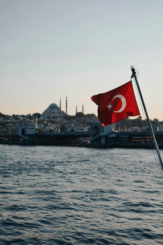 a red and white flag flying over a body of water, istanbul, during the day, evening time, profile image