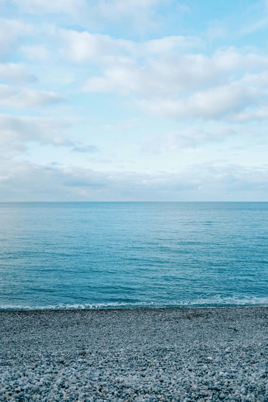 a bench sitting on top of a beach next to the ocean, unsplash, minimalism, 2 5 6 x 2 5 6 pixels, blue gray, maybe small waves, black sea