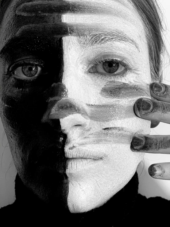 a woman with black and white paint on her face, by Maksymilian Gierymski, hand instead of a face, image split in half, transparent skin, high contrast!!