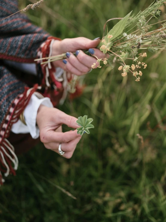 a woman holding a bunch of flowers in her hands, by Helen Stevenson, unsplash, land art, four leaf clover, runic rings, 15081959 21121991 01012000 4k, detail shot