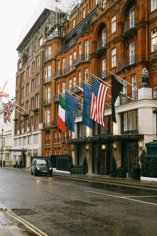 a city street filled with lots of tall buildings, a photo, unsplash, fine art, united kingdom flags, hotel, neoclassicism style, 1990s photograph