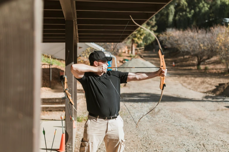 a man that is standing in the dirt with a bow, profile image