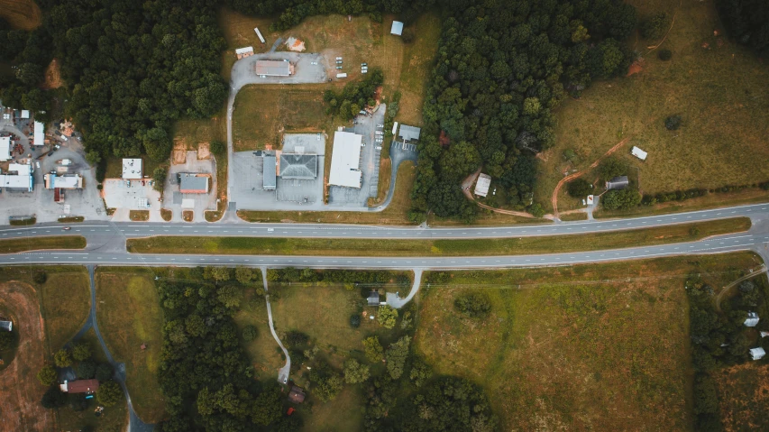 an aerial view of a small town surrounded by trees, by Carey Morris, pexels contest winner, highway, ground level shot, thumbnail, well built