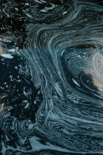 oil on the surface of a body of water, by Rudolf Schlichter, trending on unsplash, swirly tubes, ashford black marble, sewage, grain