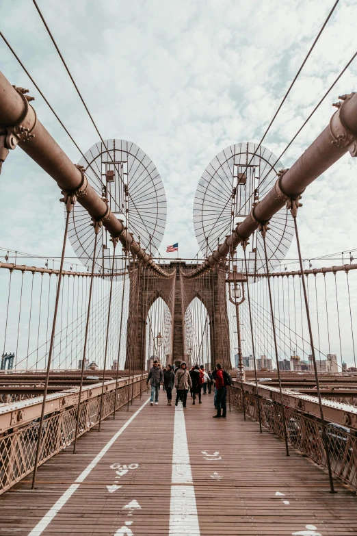 a group of people walking across a bridge, by Niko Henrichon, pexels contest winner, art nouveau, brooklyn, very wide view, elegant walkways between towers, unsplash 4k