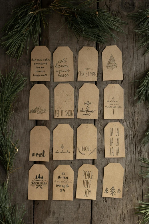 a bunch of tags sitting on top of a wooden table, organic ornaments, - 12p, tan, messages