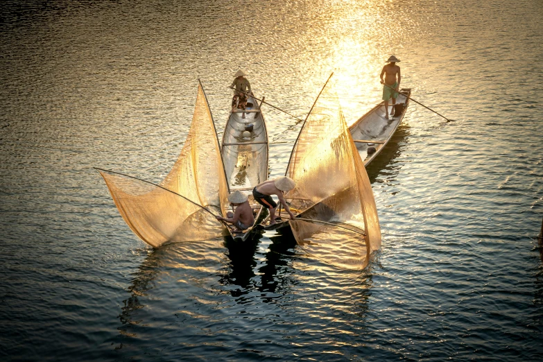 three people in small boats on a body of water, by Jesper Knudsen, pexels contest winner, hurufiyya, nets, beautiful backlight, vietnam, warm light