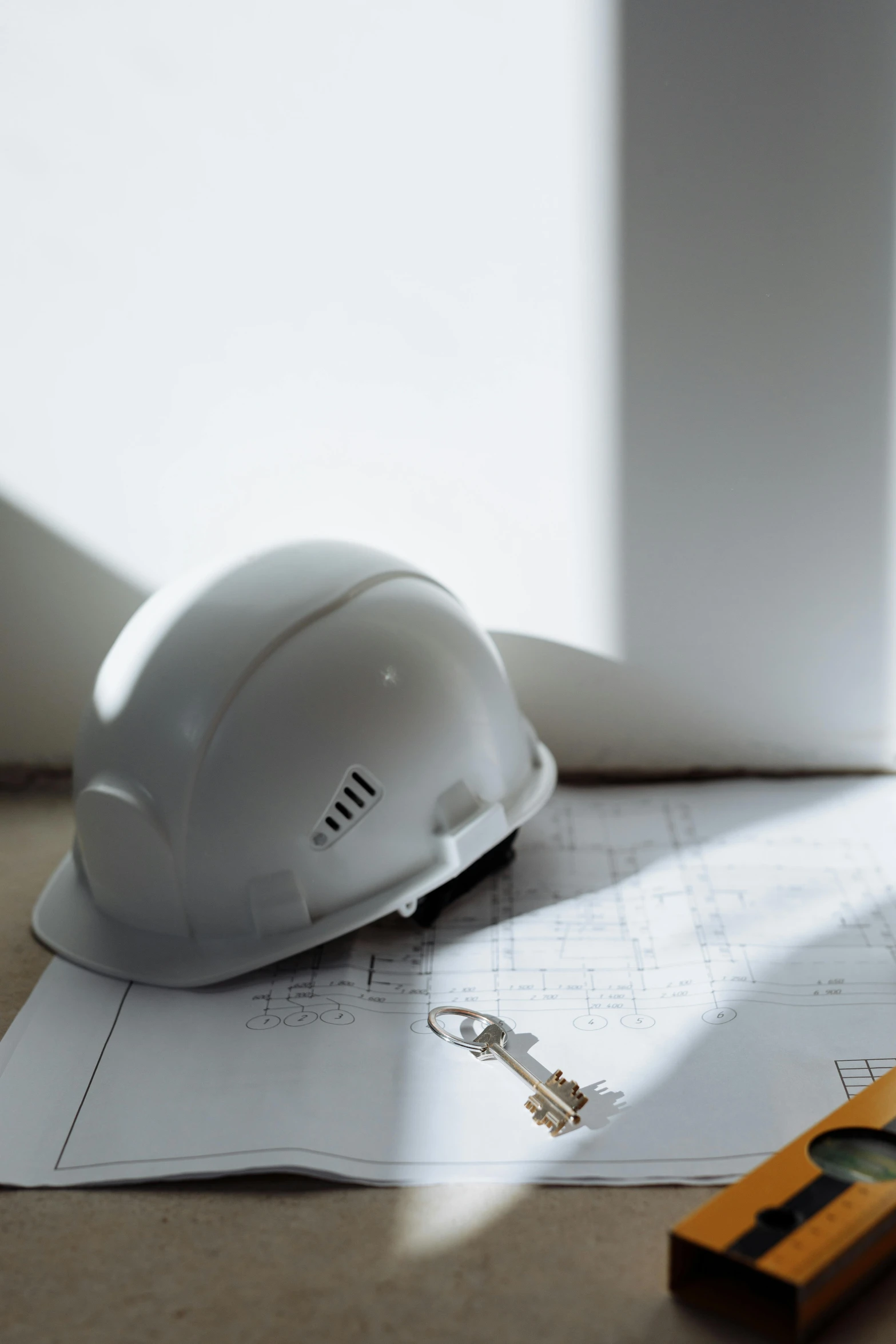 a hard hat sitting on top of a piece of paper, profile image, inside the building, detailed product image, aesthetics