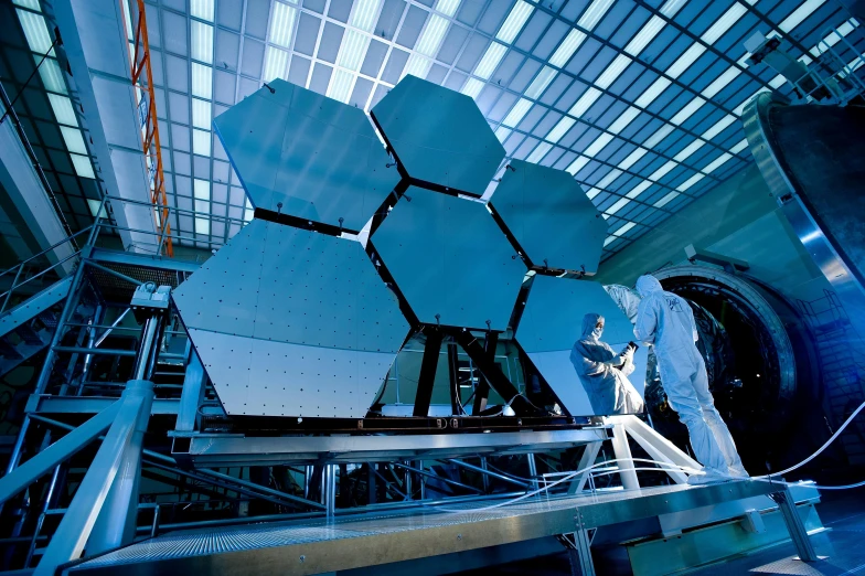 a man working on a large telescope in a building, wearing nanotech honeycomb robe, 🌸 🌼 💮, hexagons, giant star
