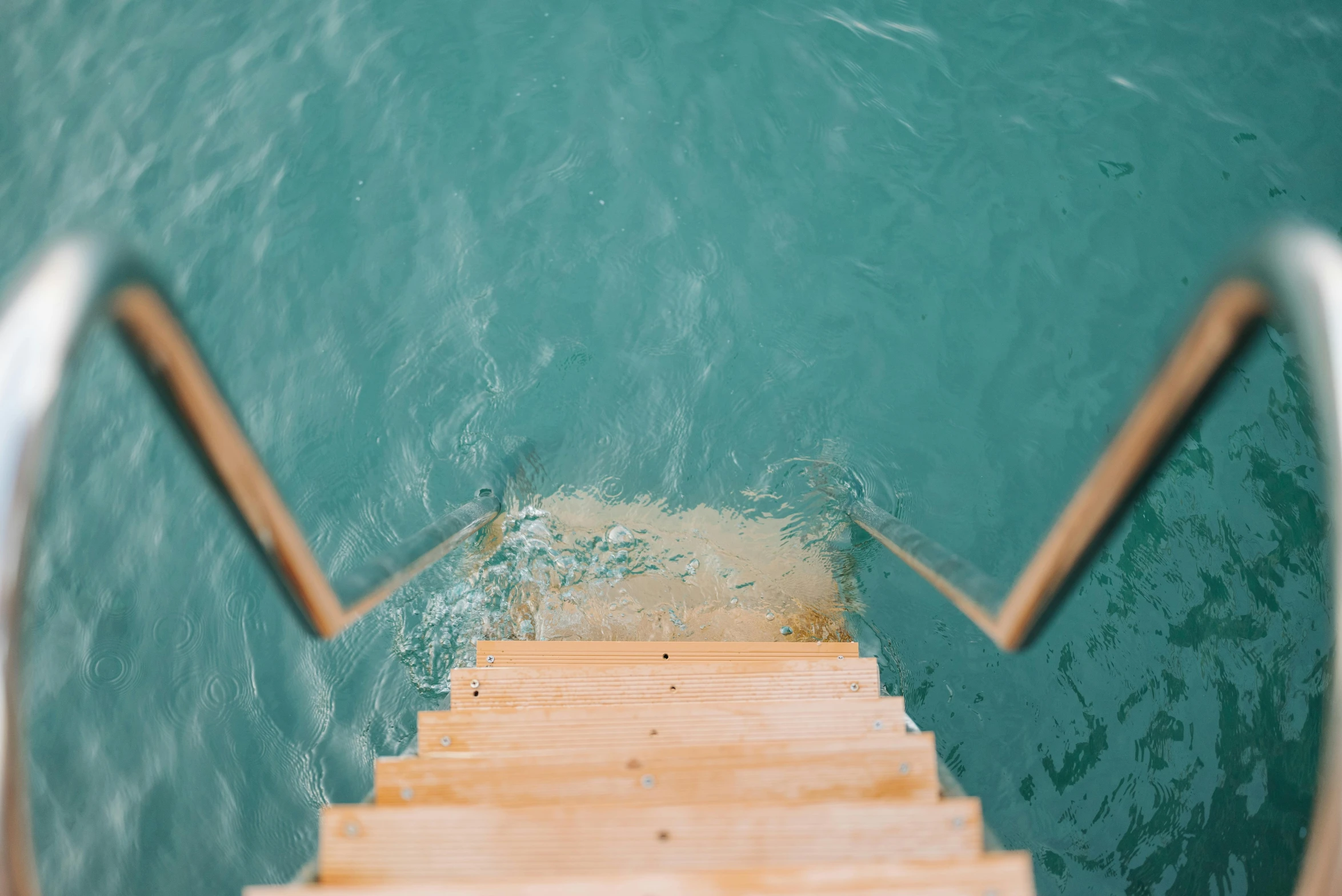 a set of stairs going down into the water, by Elsa Bleda, unsplash contest winner, happening, brown and cyan blue color scheme, thumbnail, swimming through the ocean, set sail