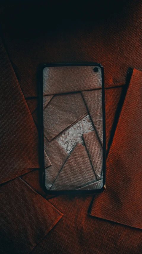 a cell phone sitting on top of a wooden table, an album cover, by Elsa Bleda, trending on pexels, modernism, leather armored, broken glass photo, pattern, brown