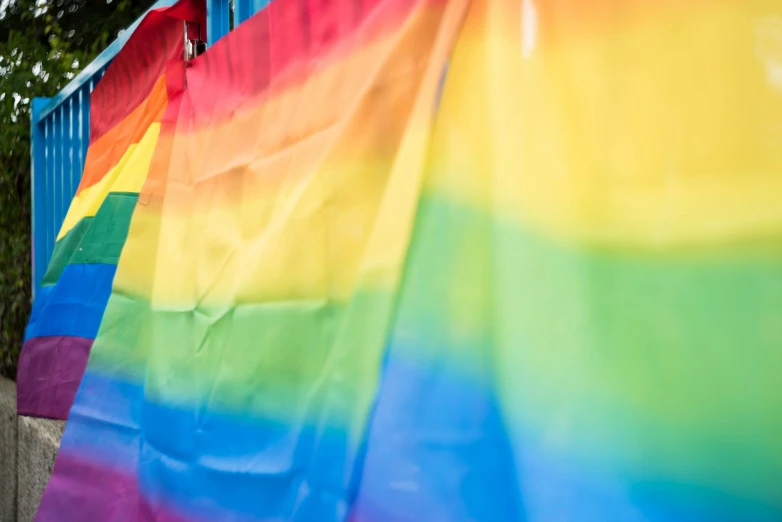 a rainbow flag hanging on the side of a building, in a colorful tent, up-close, profile image, fan favorite